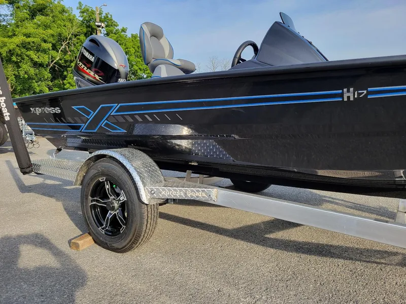 Slide: The Image of 2025 Xpress H17C Crappie boat on trailer, featuring sleek black design and Yamaha engine. - 8