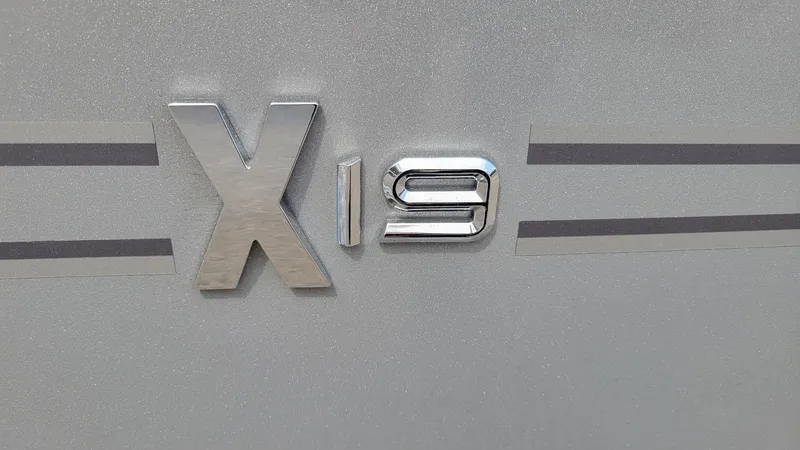 Slide: The Image of 2025 Xpress X19 Pro emblem on metallic surface, featuring sleek design elements. - 13