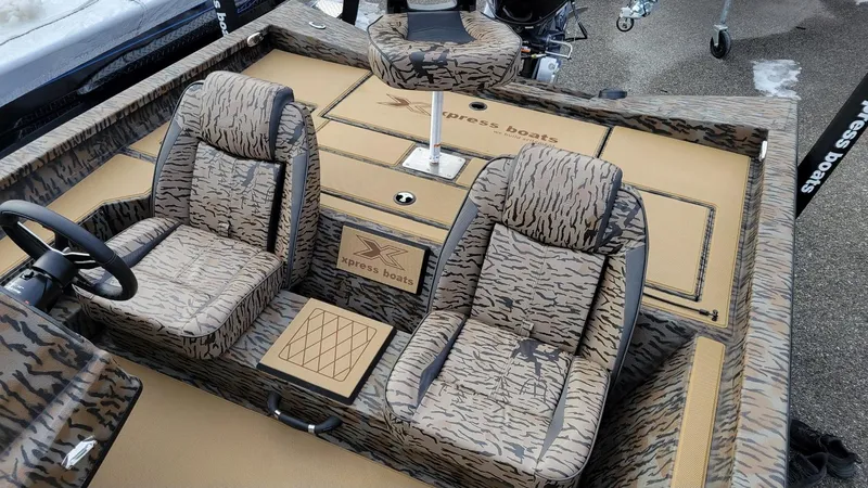 Slide: The Image of 2025 Xpress H17 Bass boat interior with camo seats and steering wheel. - 14