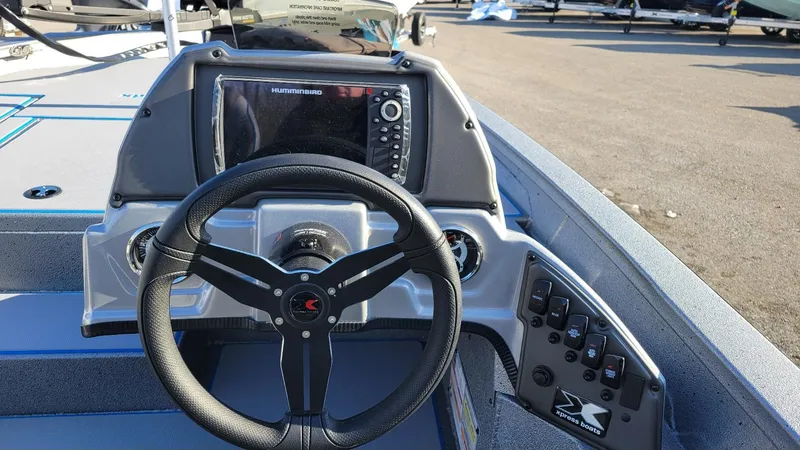 Slide: The Image of 2025 Xpress H17 Bass boat dashboard with steering wheel and Humminbird display. - 12