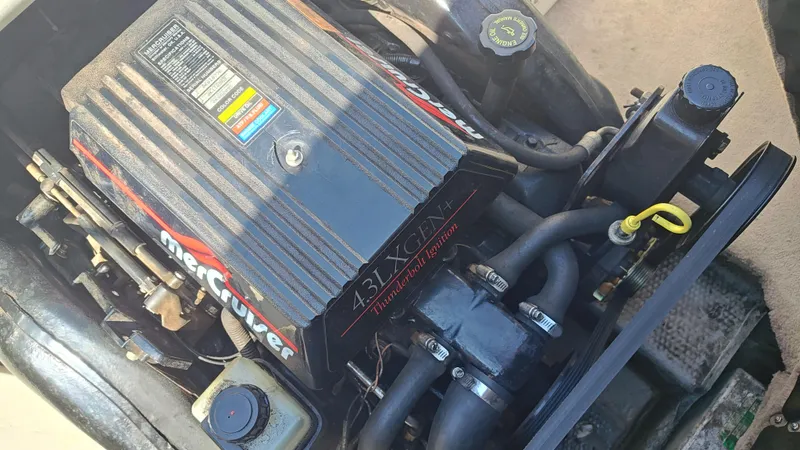 Slide: The Image of Close-up of a 1997 Rinker Festiva 212 MerCruiser engine, showcasing components and labels. - 13