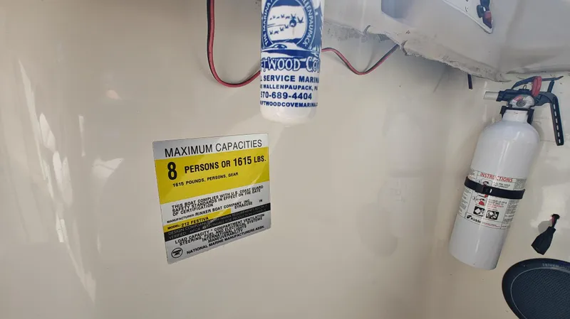 Slide: The Image of 1997 Rinker Festiva 212 capacity label, fire extinguisher, and hanging item in boat interior. - 7