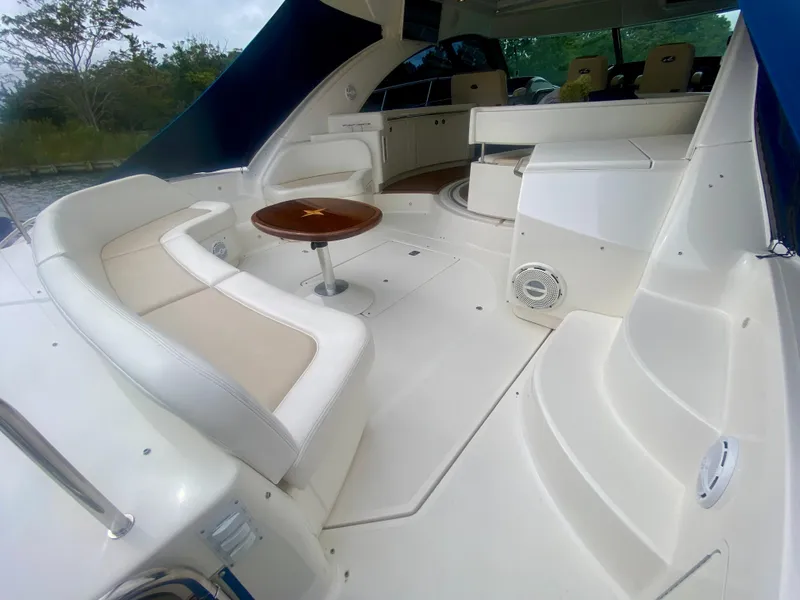 Slide: The Image of Luxurious 2013 Sea Ray 580 Sundancer yacht interior with white seating and wooden table. - 19