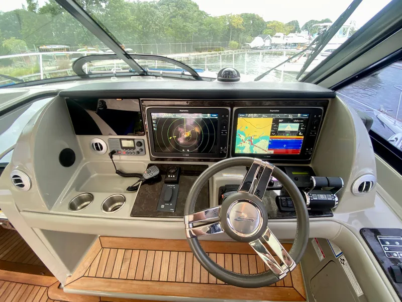 Slide: The Image of 2013 Sea Ray 580 Sundancer helm with advanced navigation displays and controls. - 48