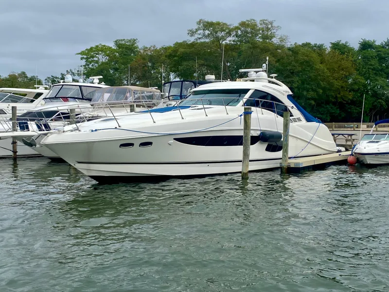 Slide: The Image of 2013 Sea Ray 580 Sundancer yacht docked in marina, surrounded by water and trees. - 3