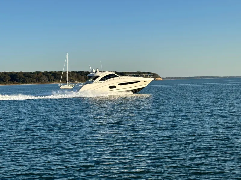 Slide: The Image of 2013 Sea Ray 580 Sundancer cruising on open water under clear skies. - 2