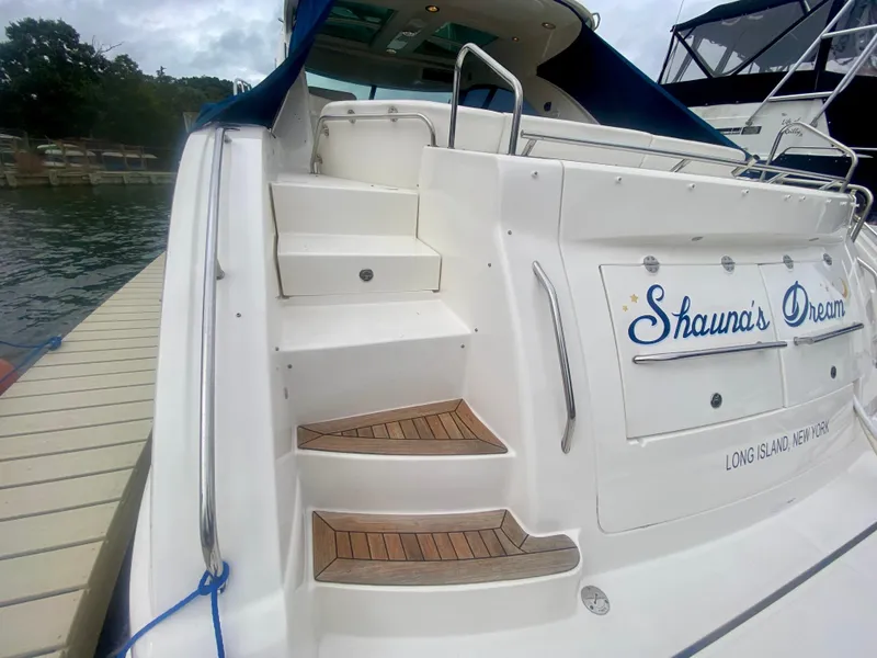 Slide: The Image of 2013 Sea Ray 580 Sundancer yacht with wooden steps and "Shauna's Dream" nameplate. - 16