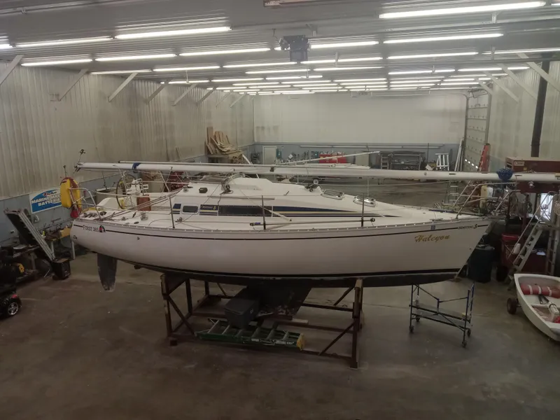 Slide: The Image of 1989 Beneteau First 285 sailboat in a spacious indoor storage facility. - 13