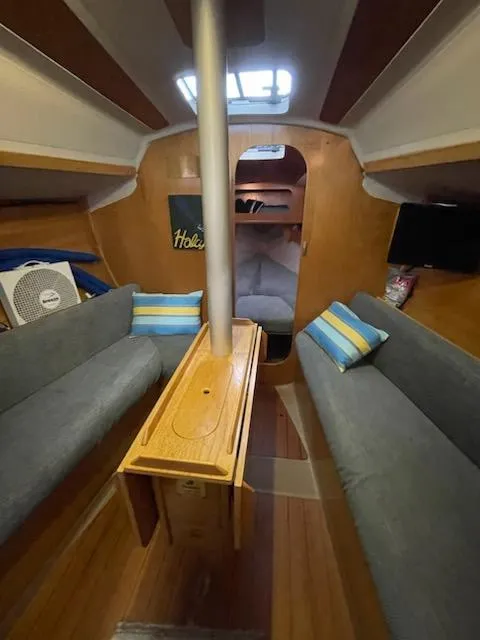 Slide: The Image of Interior of 1989 Beneteau First 285 sailboat with cozy seating and wooden table. - 7