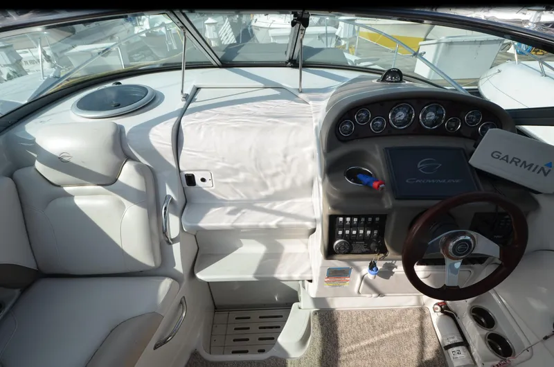 Slide: The Image of 2011 Crownline 280 CR boat cockpit with steering wheel, dashboard, and Garmin navigation system. - 10