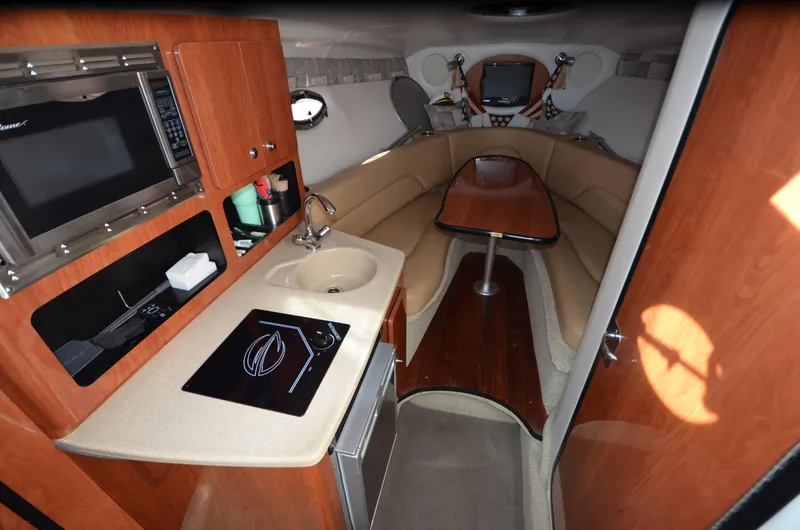 Slide: The Image of 2011 Crownline 280 CR cabin interior with kitchenette and seating area. - 11