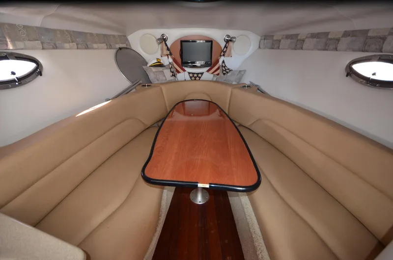 Slide: The Image of Interior of 2011 Crownline 280 CR boat with cozy seating and wooden table. - 12