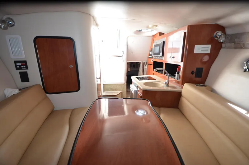 Slide: The Image of Interior of 2011 Crownline 280 CR boat with seating, table, and kitchenette. - 13