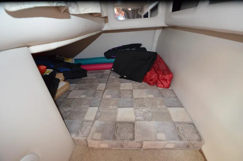 Slide: The Image of 2011 Crownline 280 CR cabin interior with storage and patterned cushions. - 15