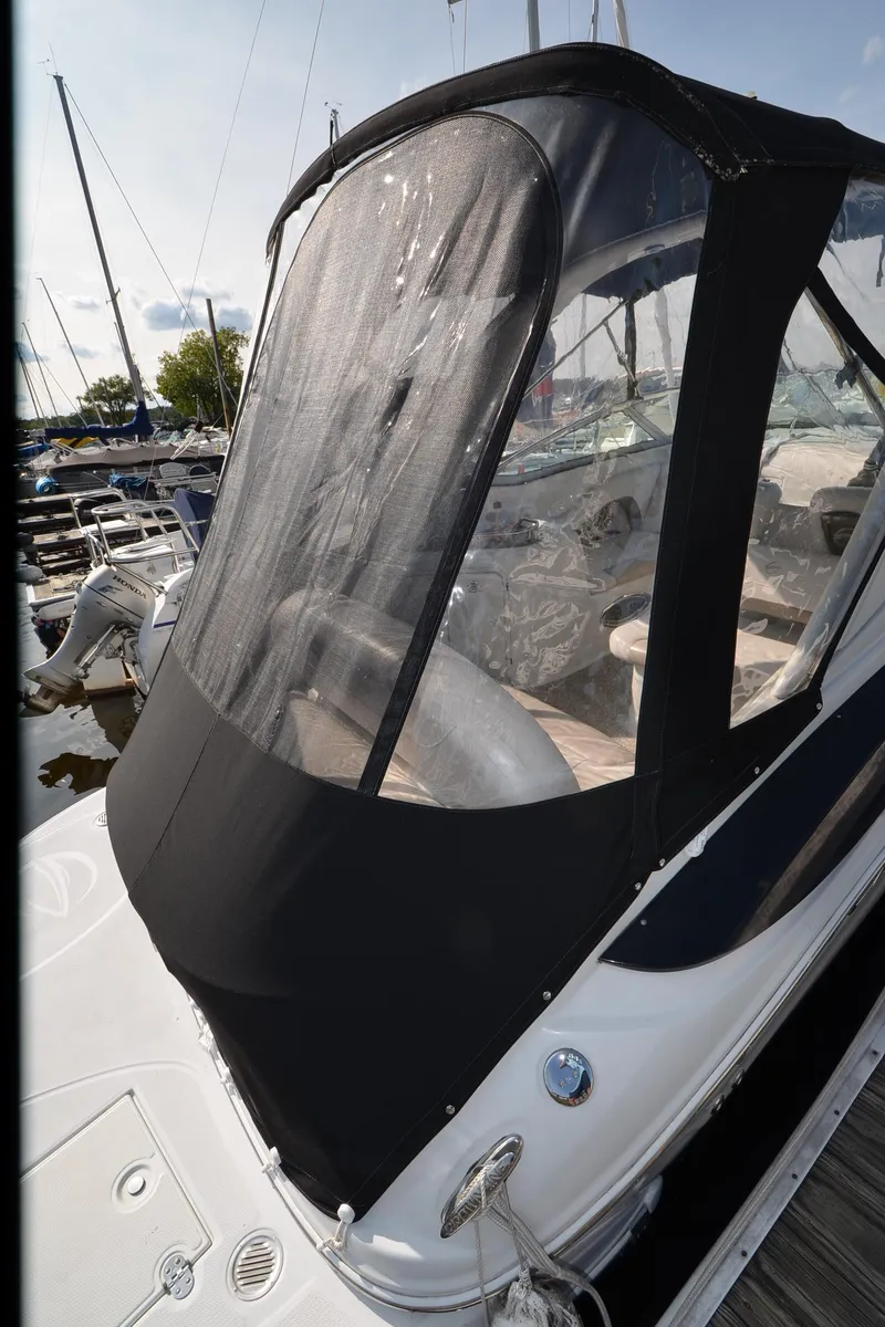 Slide: The Image of 2011 Crownline 280 CR boat with black canopy docked at marina. - 17