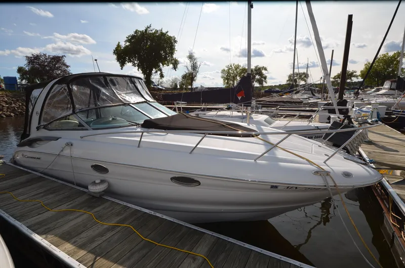 Slide: The Image of 2011 Crownline 280 CR boat docked at marina, featuring sleek design and covered cockpit. - 2