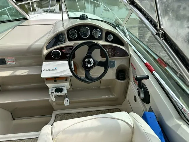 Slide: The Image of 2006 Sea Ray 260 Sundancer boat cockpit with steering wheel and Garmin navigation system. - 5