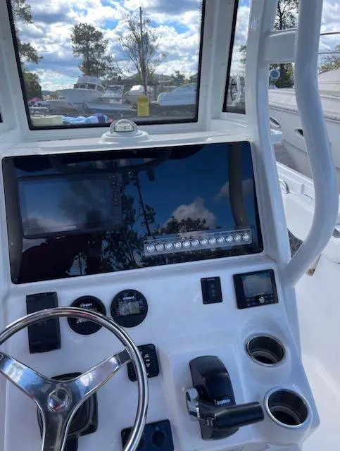 Slide: The Image of 2022 Tidewater 232 LXF boat dashboard with steering wheel and control panel. - 2