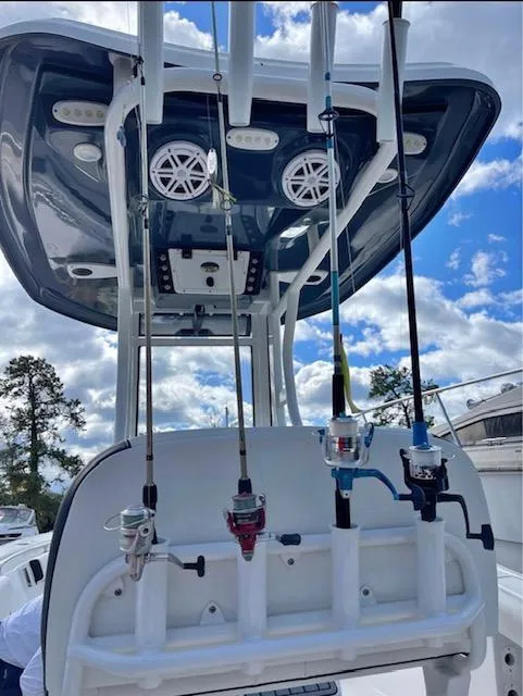 Slide: The Image of 2022 Tidewater 232 LXF boat with fishing rods and T-top against a cloudy sky. - 3