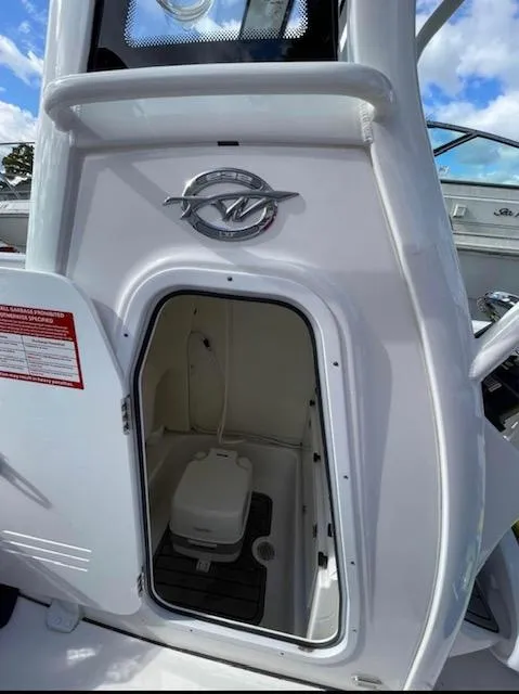 Slide: The Image of 2022 Tidewater 232 LXF boat with open storage compartment and visible toilet. - 6