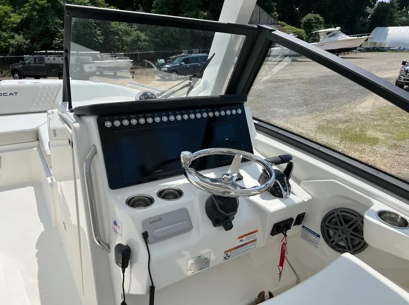 Slide: The Image of 2024 World Cat 260 DC-X boat dashboard with steering wheel and controls. - 11