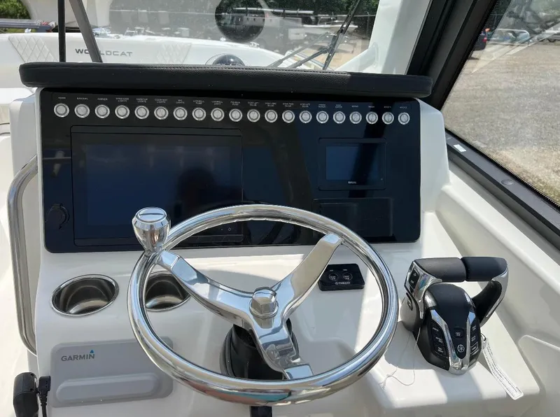 Slide: The Image of 2024 World Cat 260 DC-X boat dashboard with steering wheel and controls. - 14