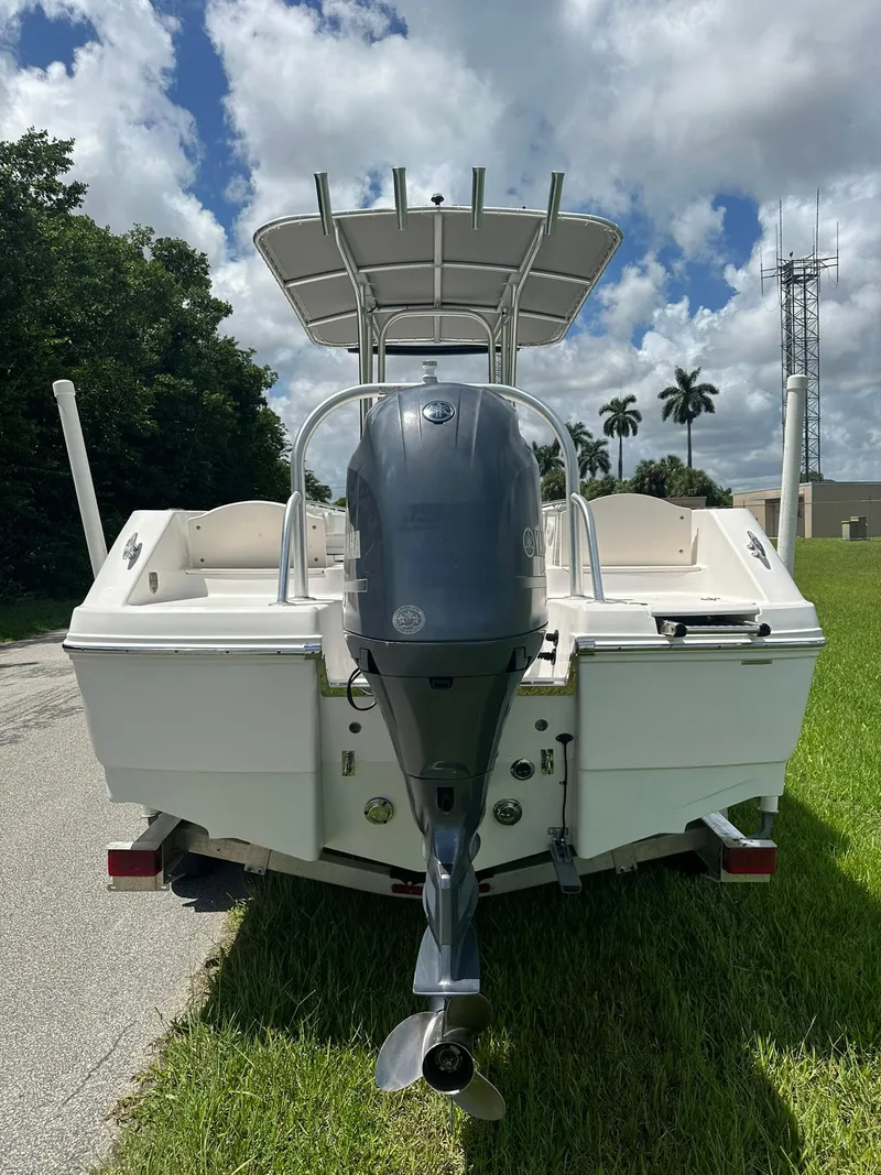 Slide: The Image of 2016 Robalo R200 Center Console boat, rear view, parked on grass under cloudy sky. - 4