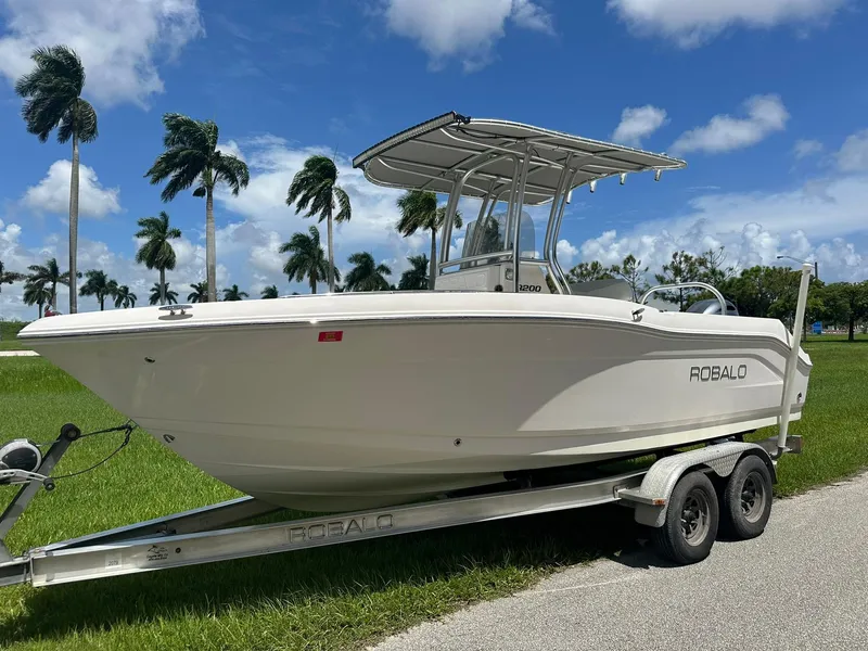 Slide: The Image of 2016 Robalo R200 Center Console boat on trailer, parked near palm trees. - 7
