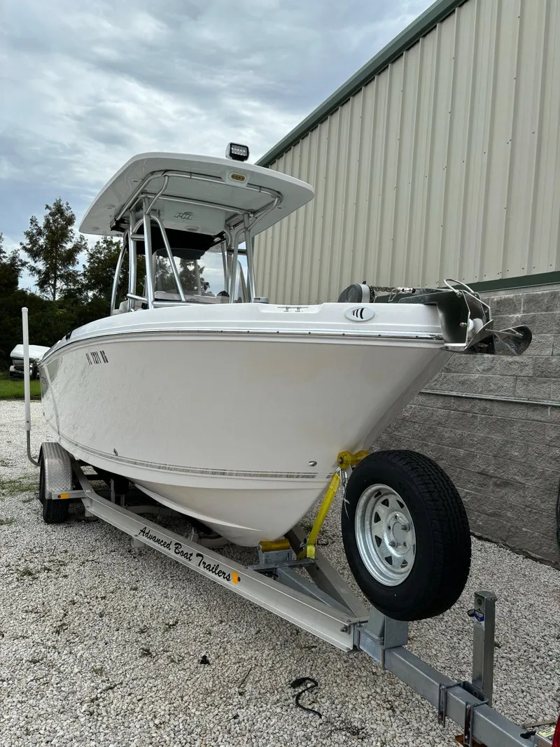 Slide: The Image of 2017 Pro-Line 23 Sport boat on trailer, parked outdoors. - 2