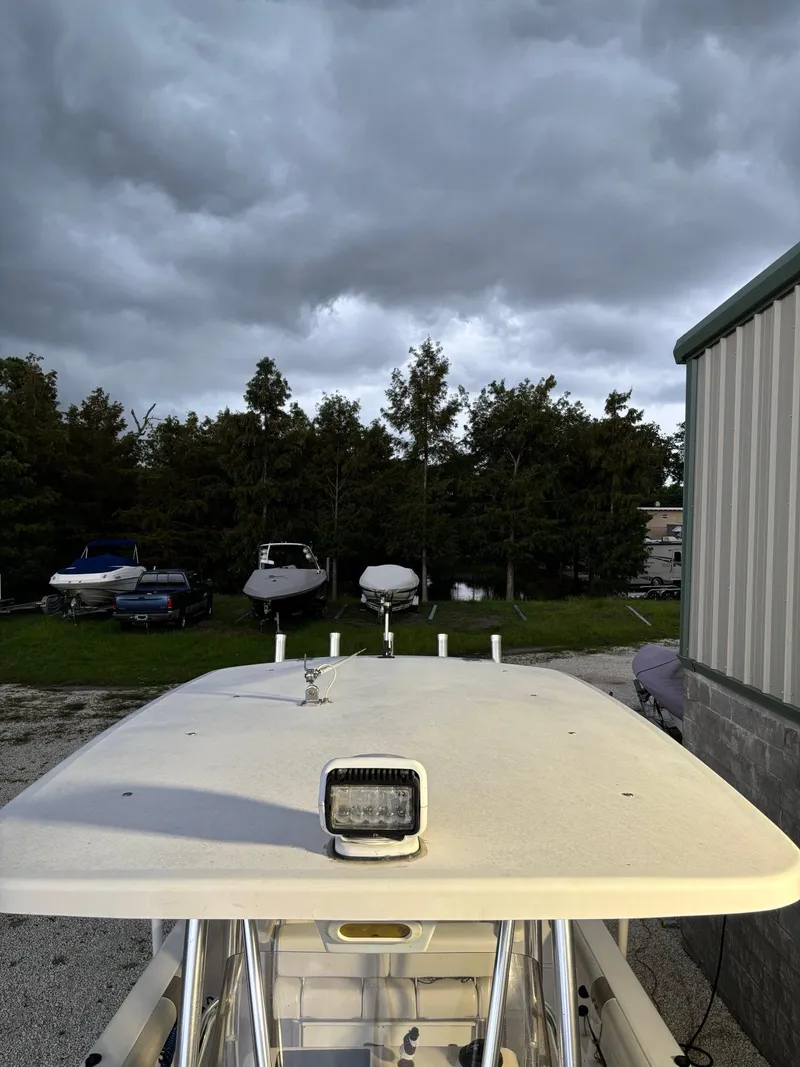 Slide: The Image of 2017 Pro-Line 23 Sport boat under cloudy sky, parked near other boats. - 26
