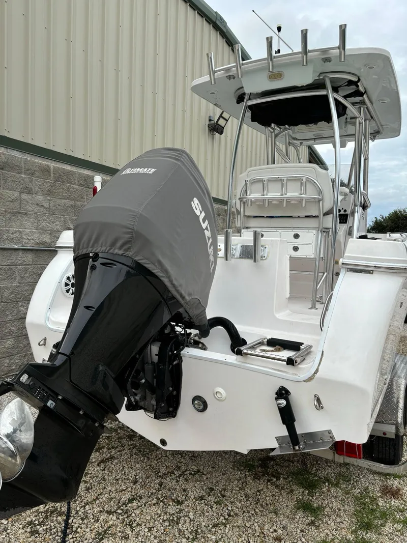Slide: The Image of 2017 Pro-Line 23 Sport boat with Suzuki outboard motor, parked near a building. - 28