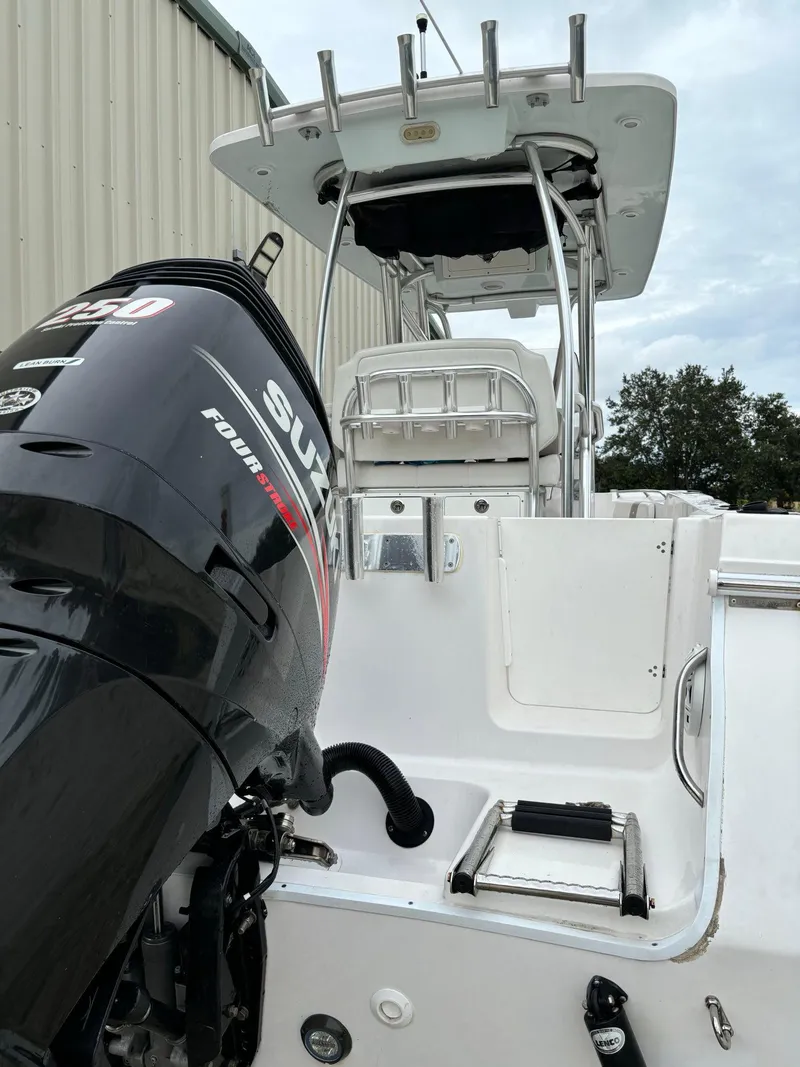 Slide: The Image of 2017 Pro-Line 23 Sport boat with Suzuki outboard motor, docked near a building. - 32