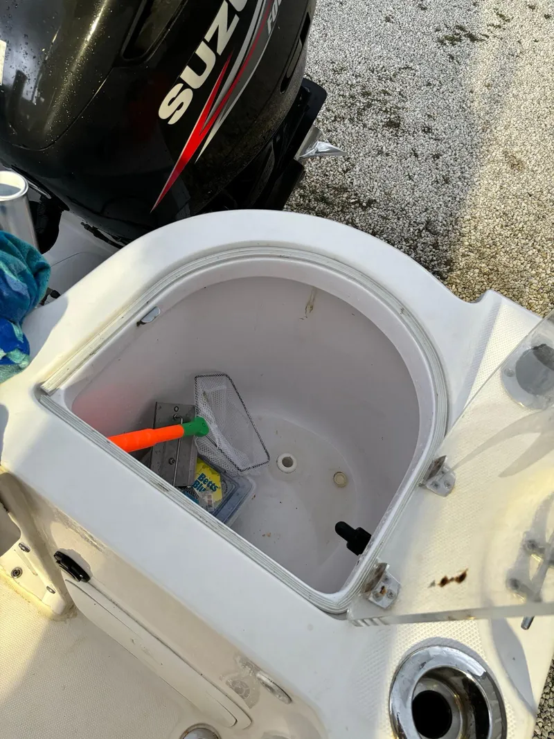 Slide: The Image of 2017 Pro-Line 23 Sport boat with open storage compartment and Suzuki engine. - 34