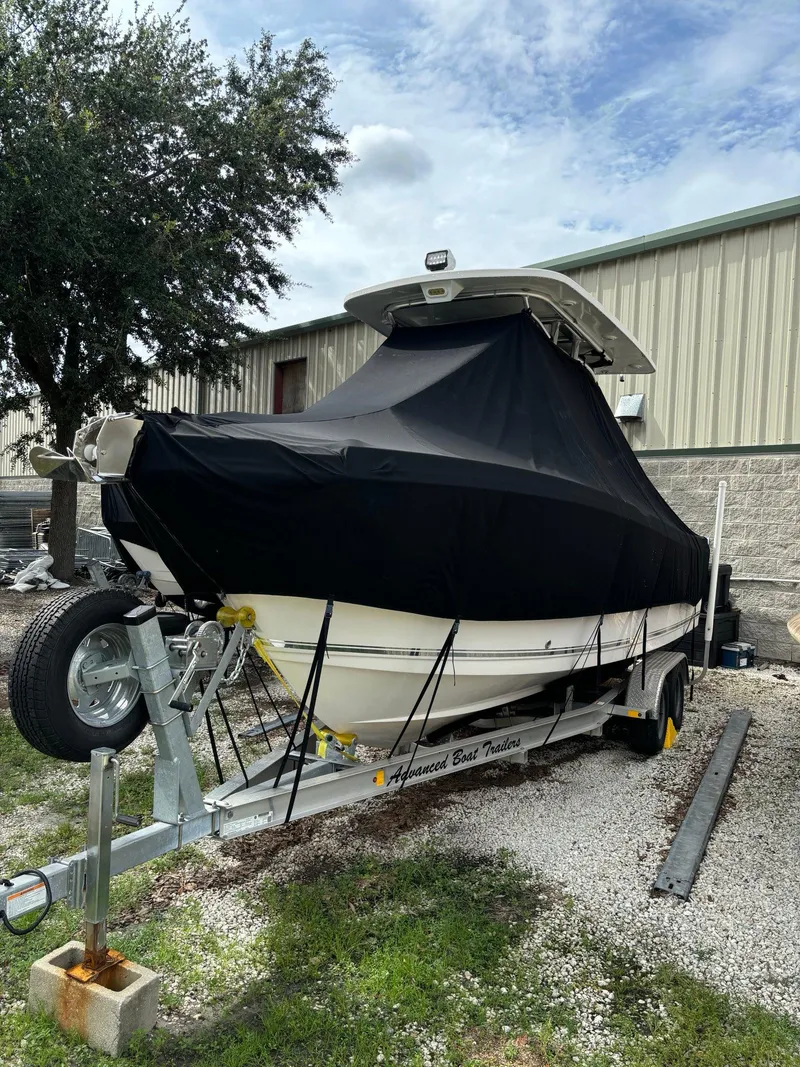 Slide: The Image of 2017 Pro-Line 23 Sport boat covered on trailer, parked outdoors. - 5