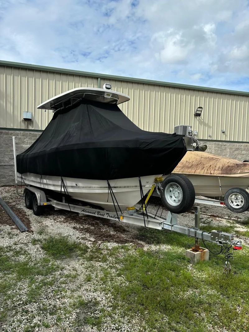 Slide: The Image of 2017 Pro-Line 23 Sport boat covered on trailer, parked outdoors. - 6