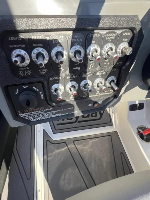 Slide: The Image of Control panel of 2023 Heyday WTSurf boat with various switches and warnings. - 12