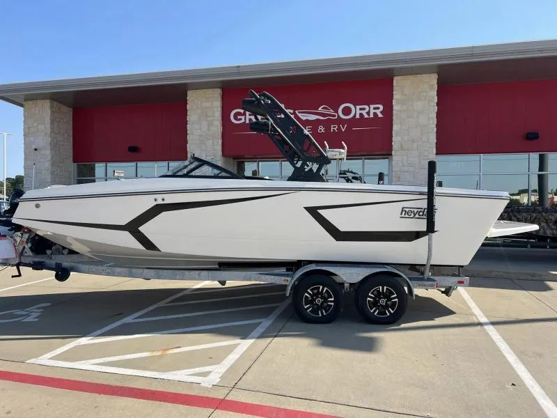 Slide: The Image of 2023 Heyday WTSurf boat on trailer outside dealership. - 2