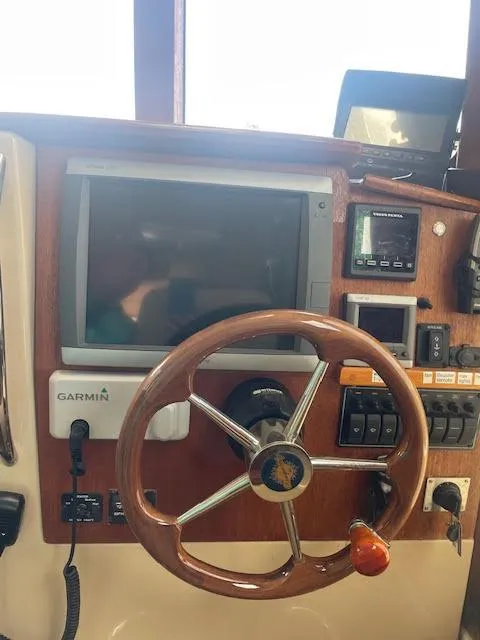 Slide: The Image of 2013 Ranger Tugs R-31CB helm with Garmin navigation system and wooden steering wheel. - 135