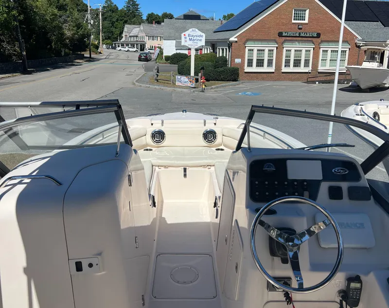 Slide: The Image of 2015 Grady-White 225 Freedom boat interior with steering wheel and dashboard, parked near a marina. - 3