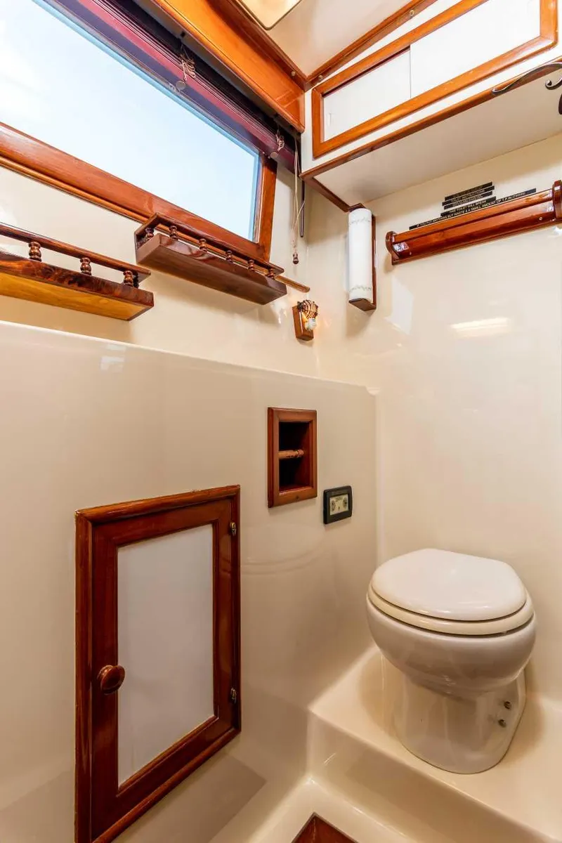 Slide: The Image of 1984 Marine Trader Aft Cabin Motor Yacht bathroom with wooden accents and compact design. - 13