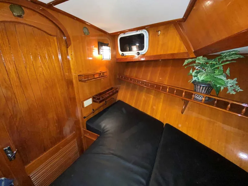 Slide: The Image of 1984 Marine Trader Aft Cabin Motor Yacht interior with wood paneling and cozy seating. - 15