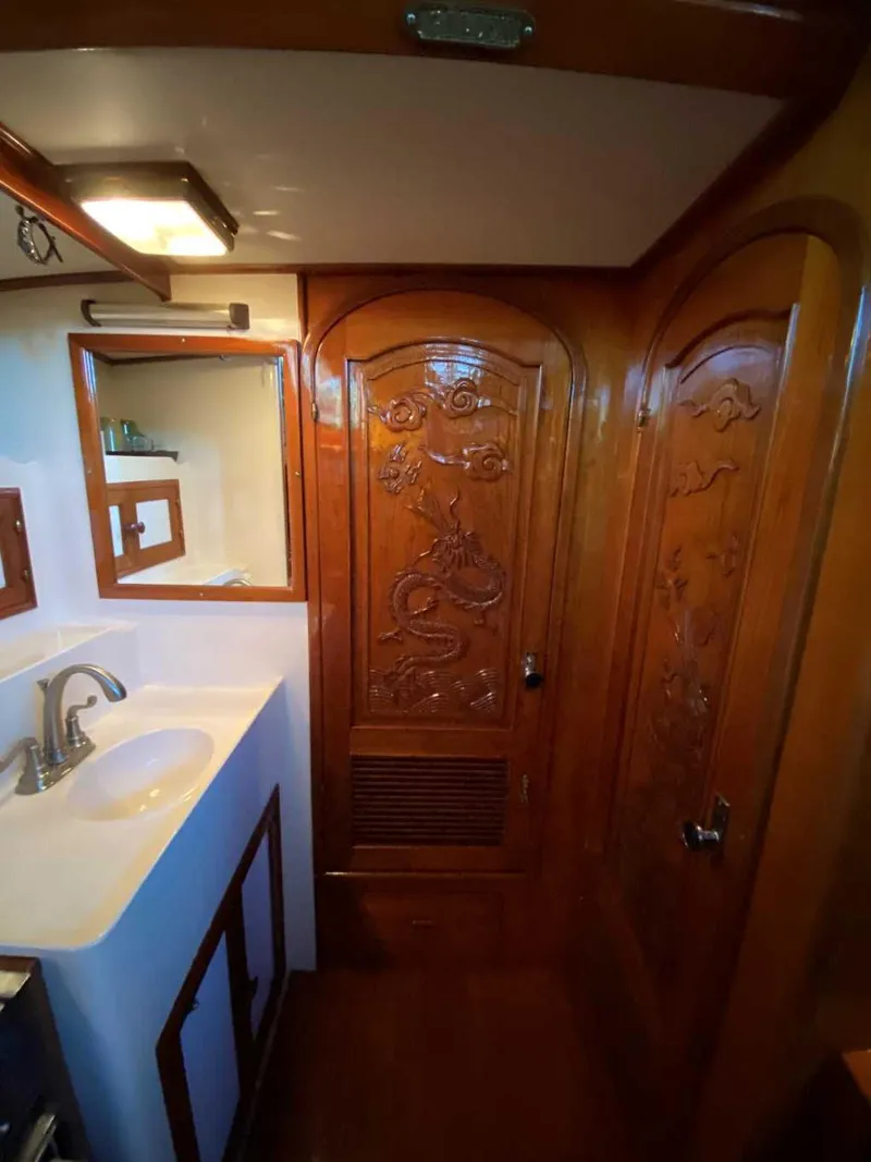 Slide: The Image of 1984 Marine Trader Aft Cabin Yacht bathroom with carved wooden doors and sink. - 16