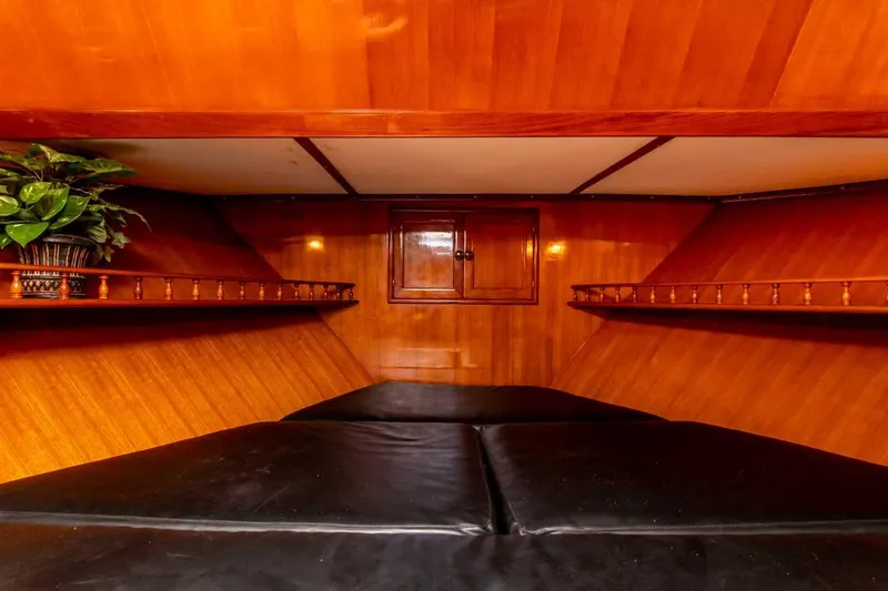 Slide: The Image of 1984 Marine Trader Aft Cabin Motor Yacht interior with wood paneling and black cushions. - 17