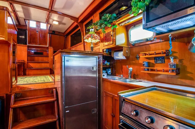 Slide: The Image of 1984 Marine Trader Aft Cabin Motor Yacht interior with wood finish and kitchen amenities. - 20