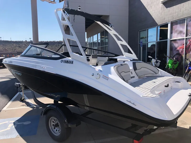 Slide: The Image of 2025 Yamaha Boats AR190, sleek black and white design, parked outdoors. - 13