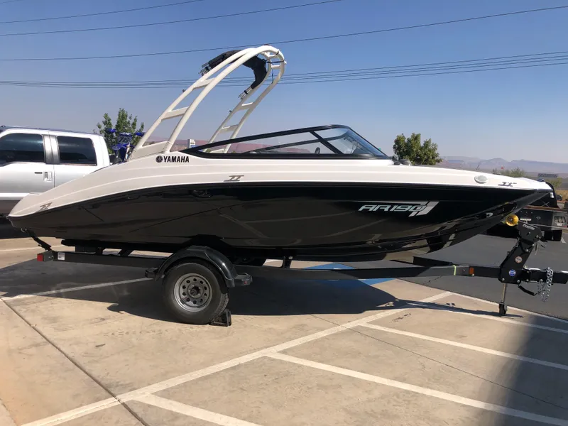 Slide: The Image of 2025 Yamaha AR190 boat on trailer, parked outdoors, side view. - 2
