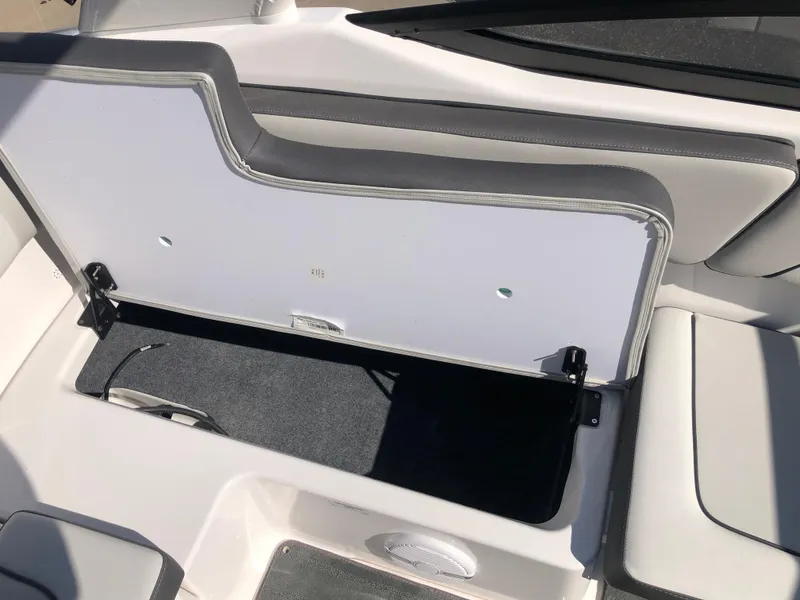 Slide: The Image of 2025 Yamaha Boats AR190 storage compartment with open lid, showcasing interior space. - 22