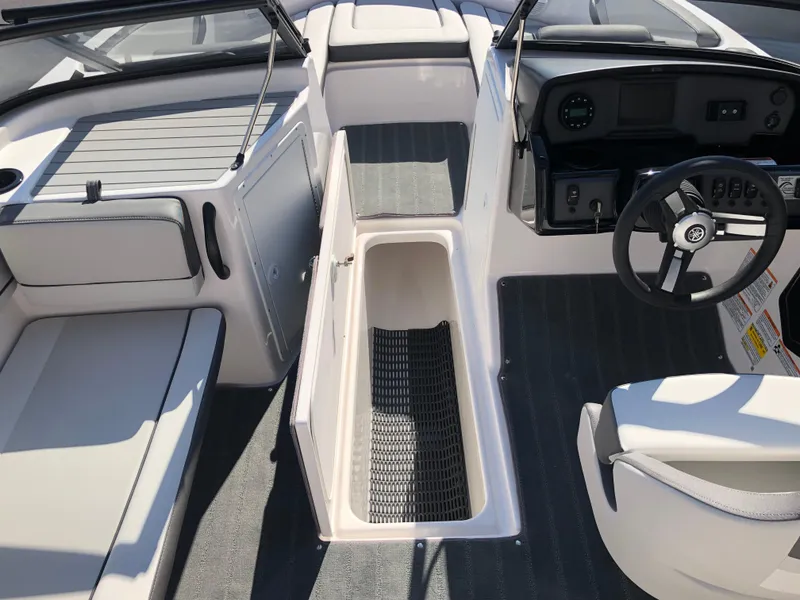 Slide: The Image of 2025 Yamaha Boats AR190 interior with open storage compartment and steering wheel. - 25