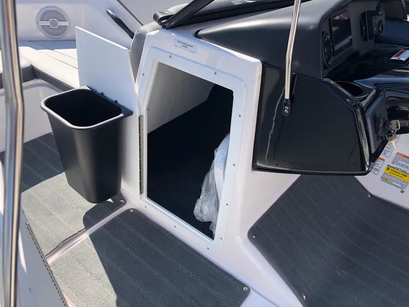 Slide: The Image of 2025 Yamaha Boats AR190 interior with storage compartment and black trash bin. - 35