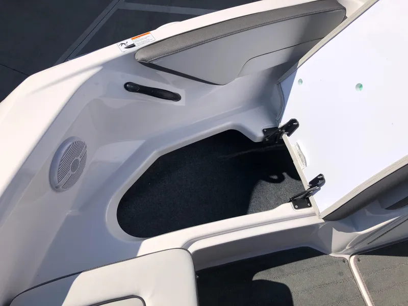Slide: The Image of 2025 Yamaha Boats AR190 interior storage compartment with speaker and seating area. - 40